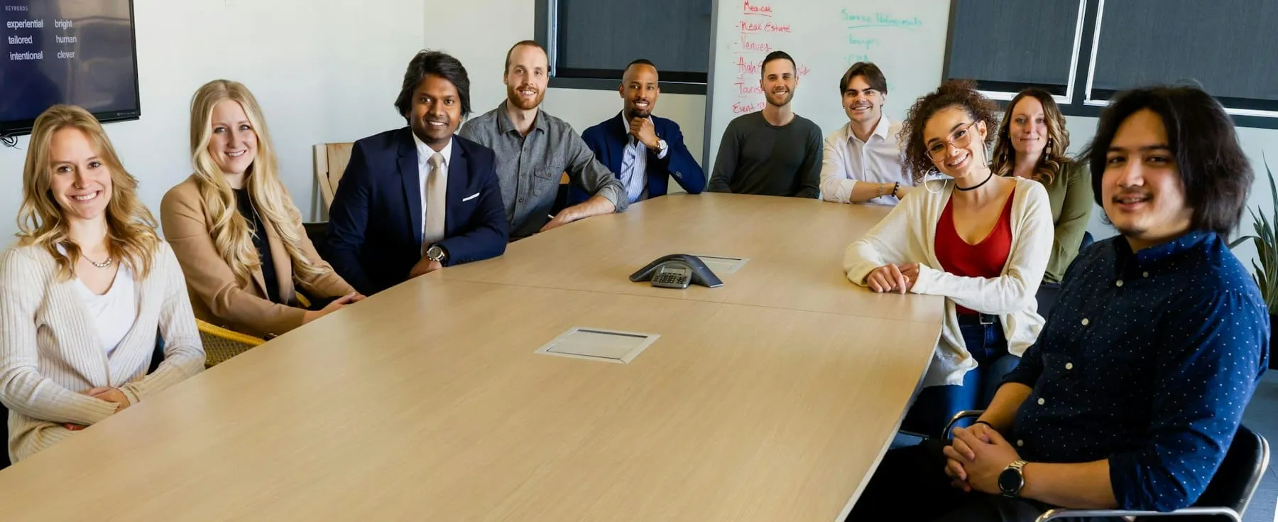 A team meeting around a long table in a bright conference room