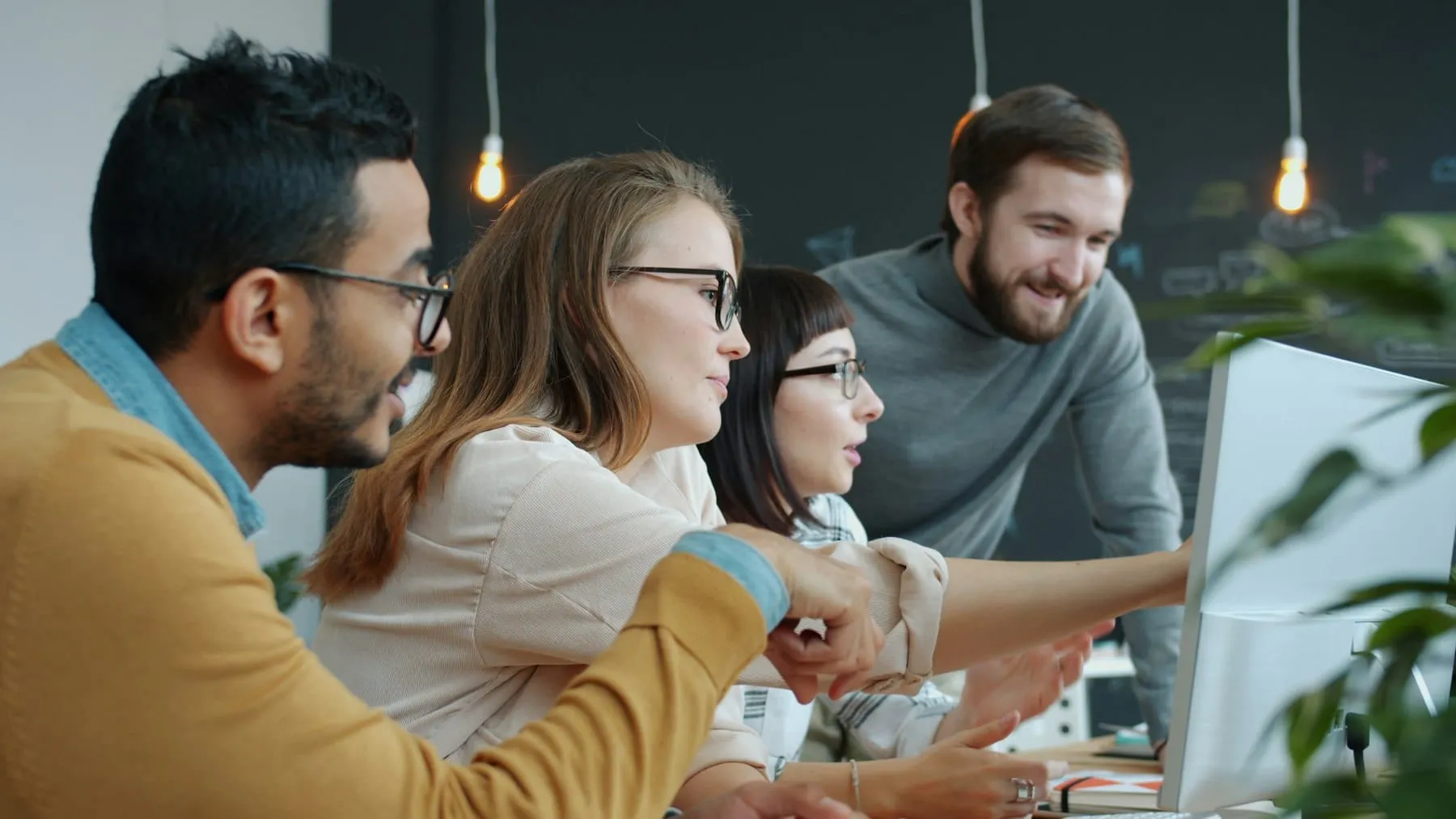 Het team aan het werk aan een lange tafel in een lichte vergaderruimte