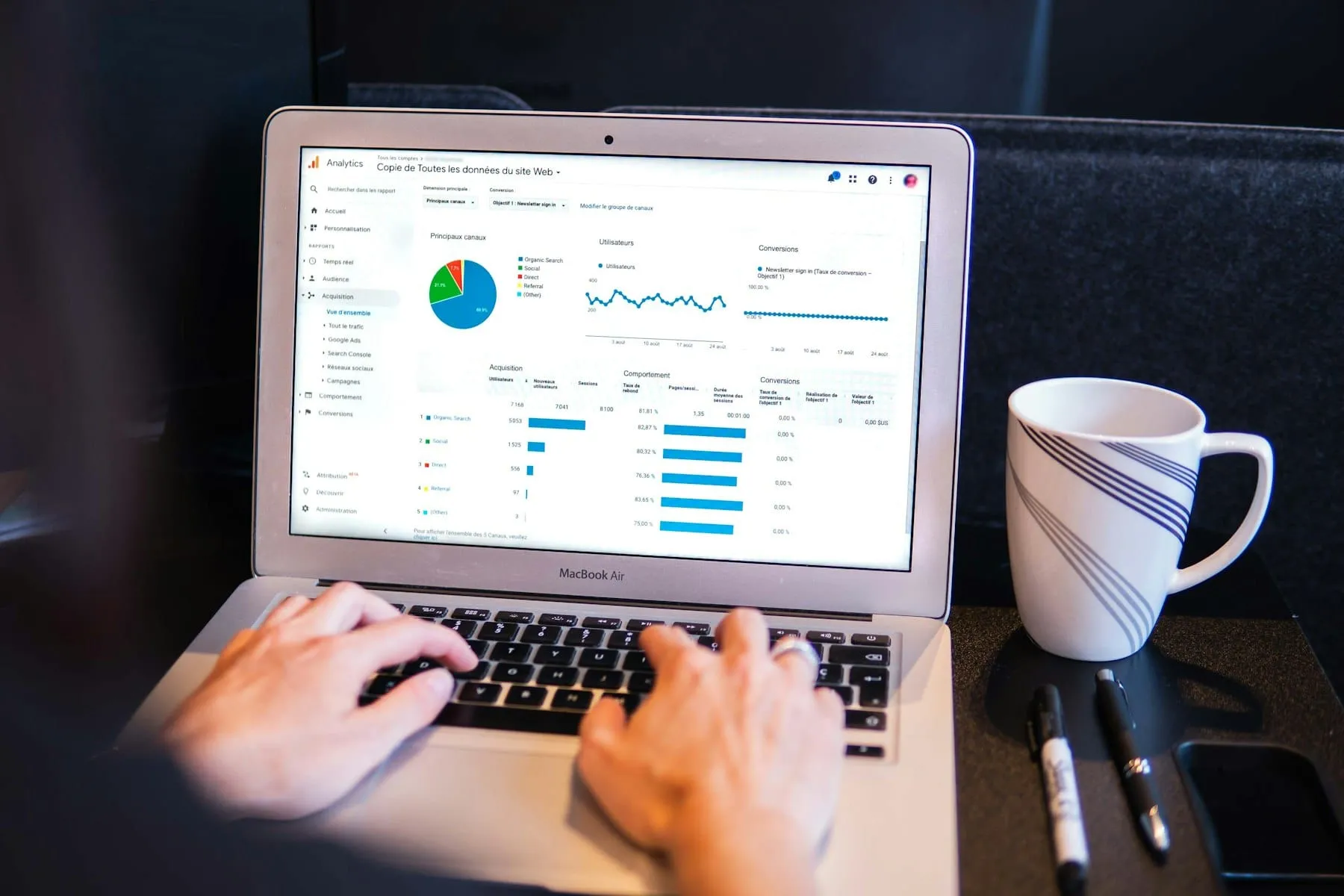 A person pointing at a website traffic chart on a laptop screen