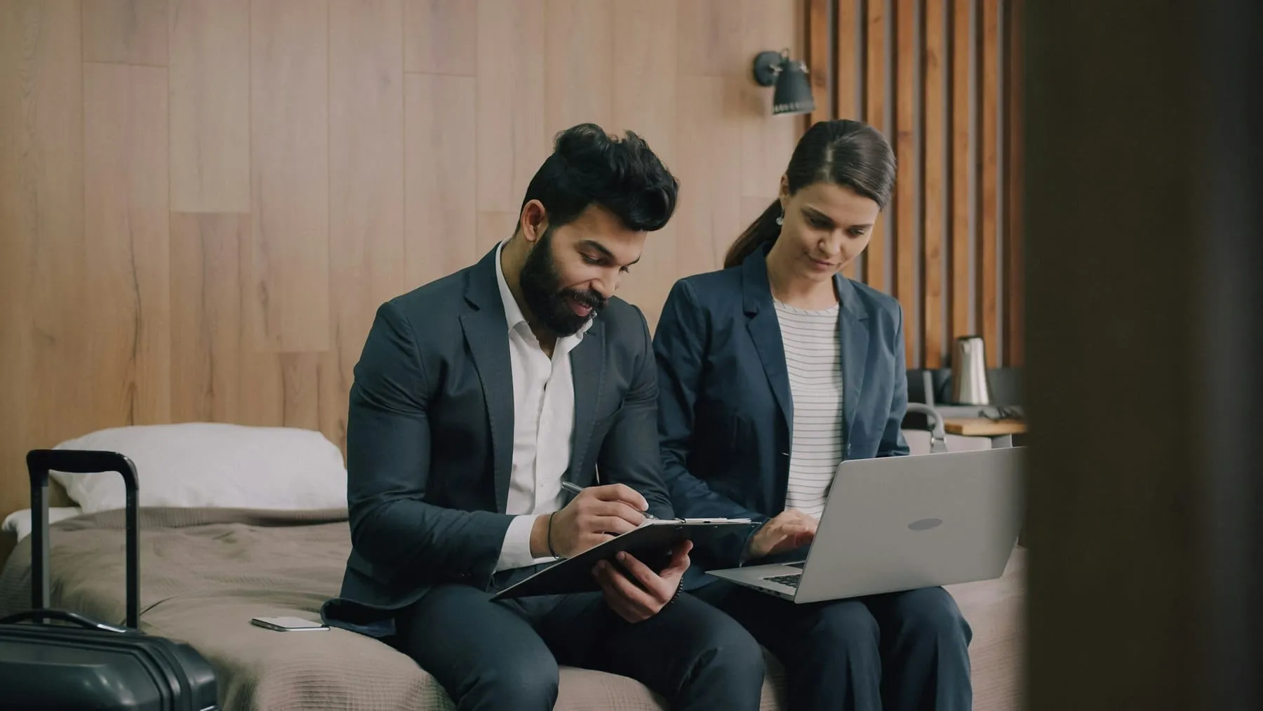 Drie collega’s bespreken het plan van een hotelklant