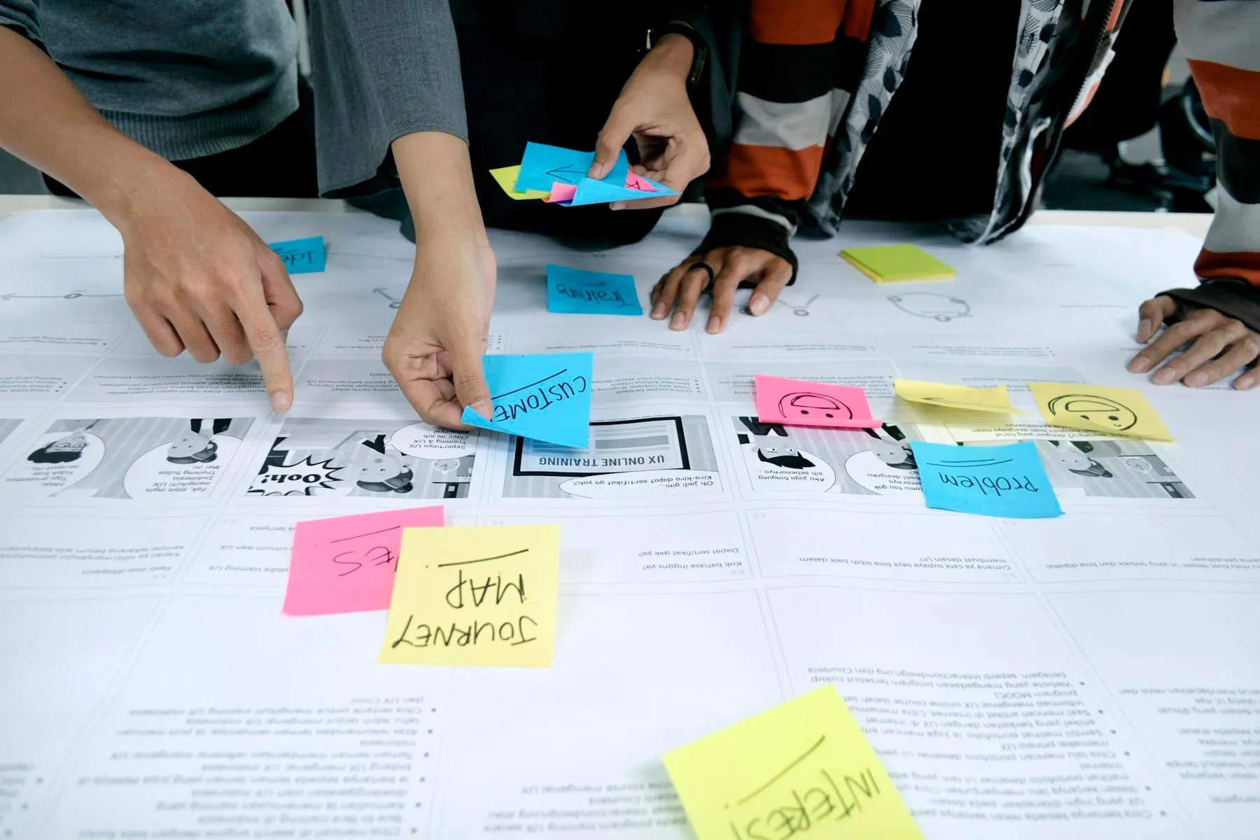 A team planning around a table with color swatches, notes and coffee