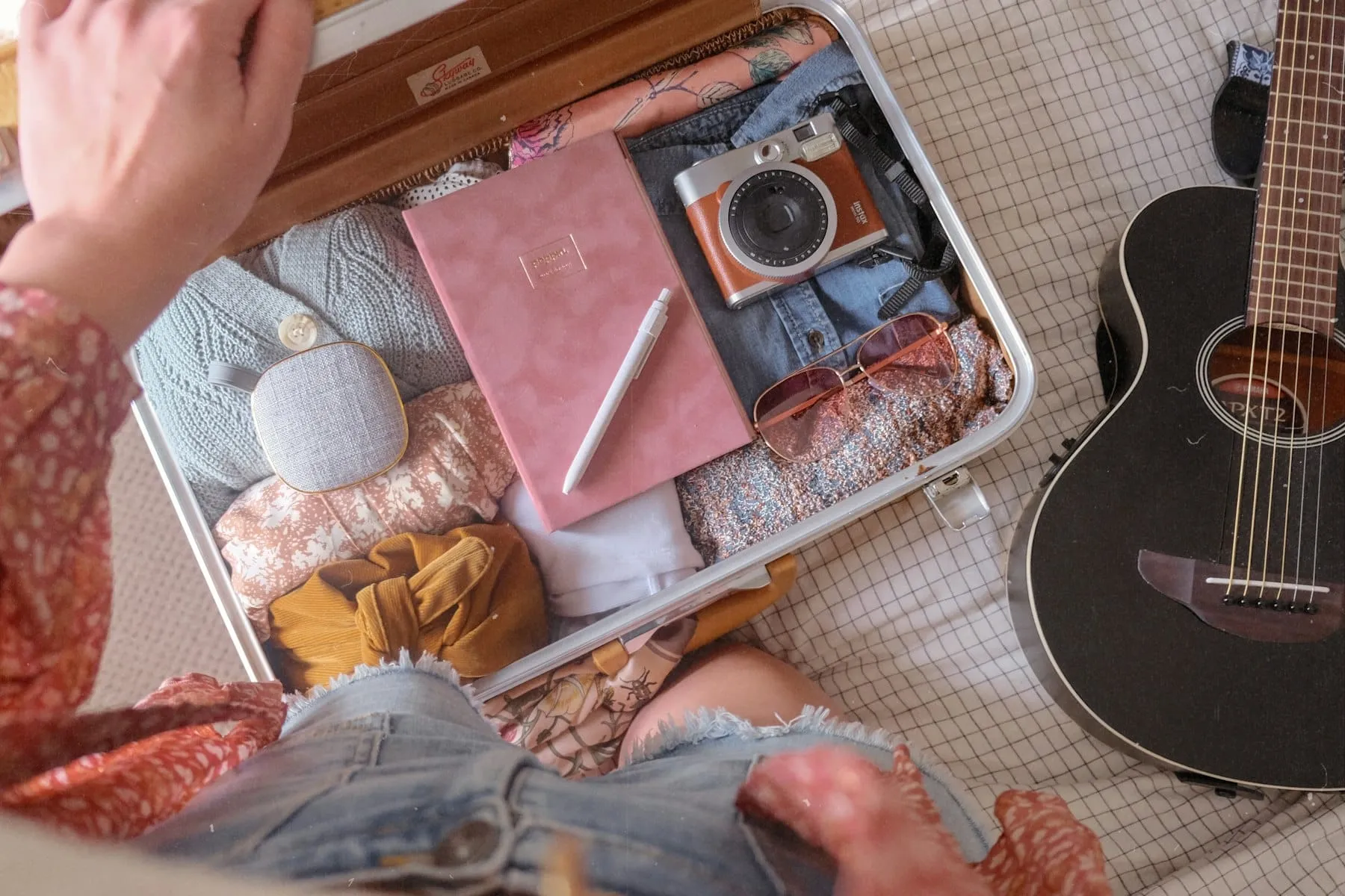 A traveler with a packed suitcase comparing hotels on a laptop