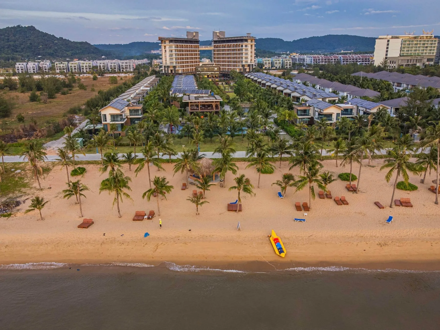 Ảnh chụp từ trên cao một resort ở Phú Quốc với hồ bơi, vườn cây và các biệt thự mái xanh