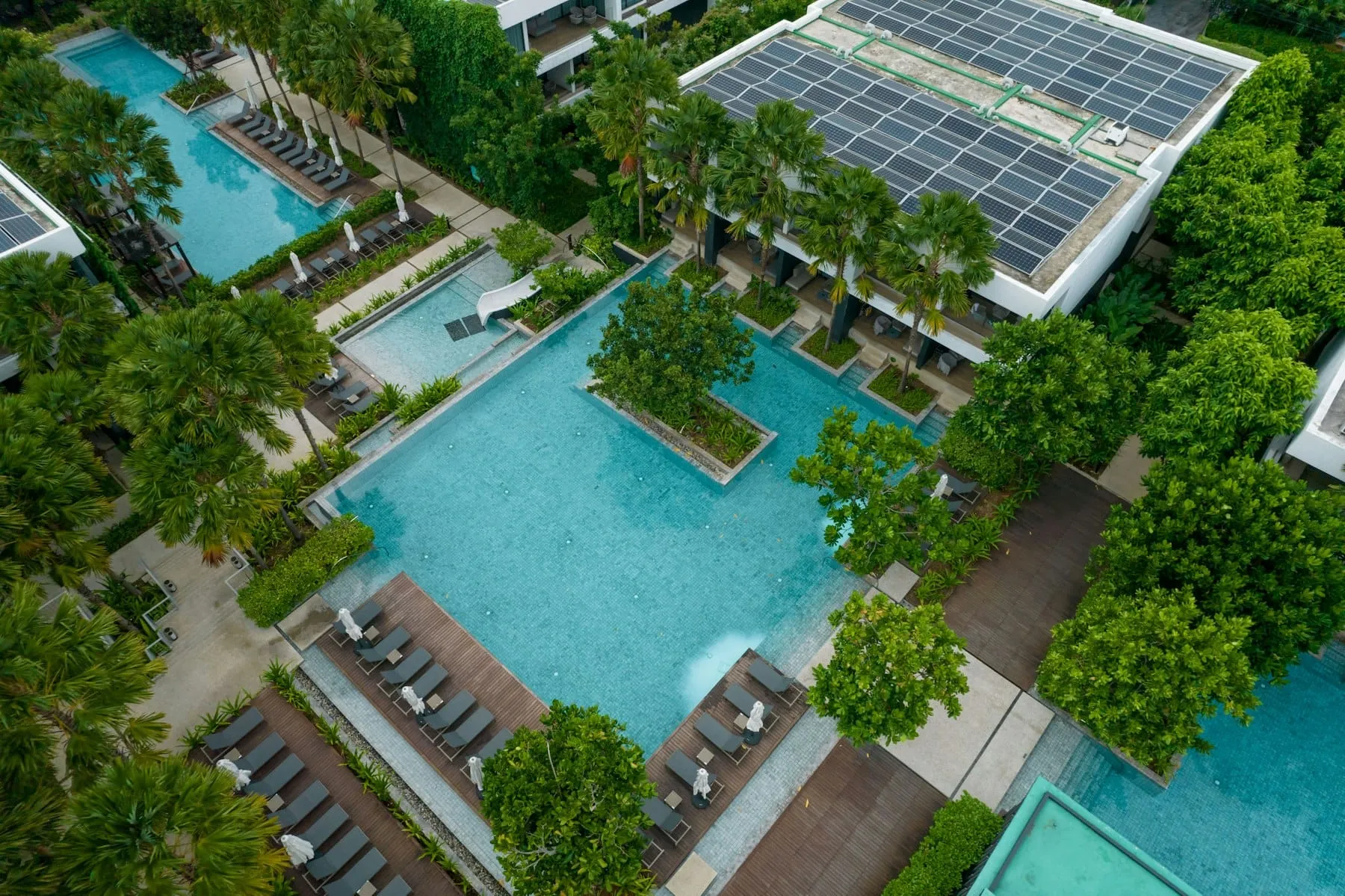 Aerial view of a resort pool surrounded by palm trees and villas in Vietnam