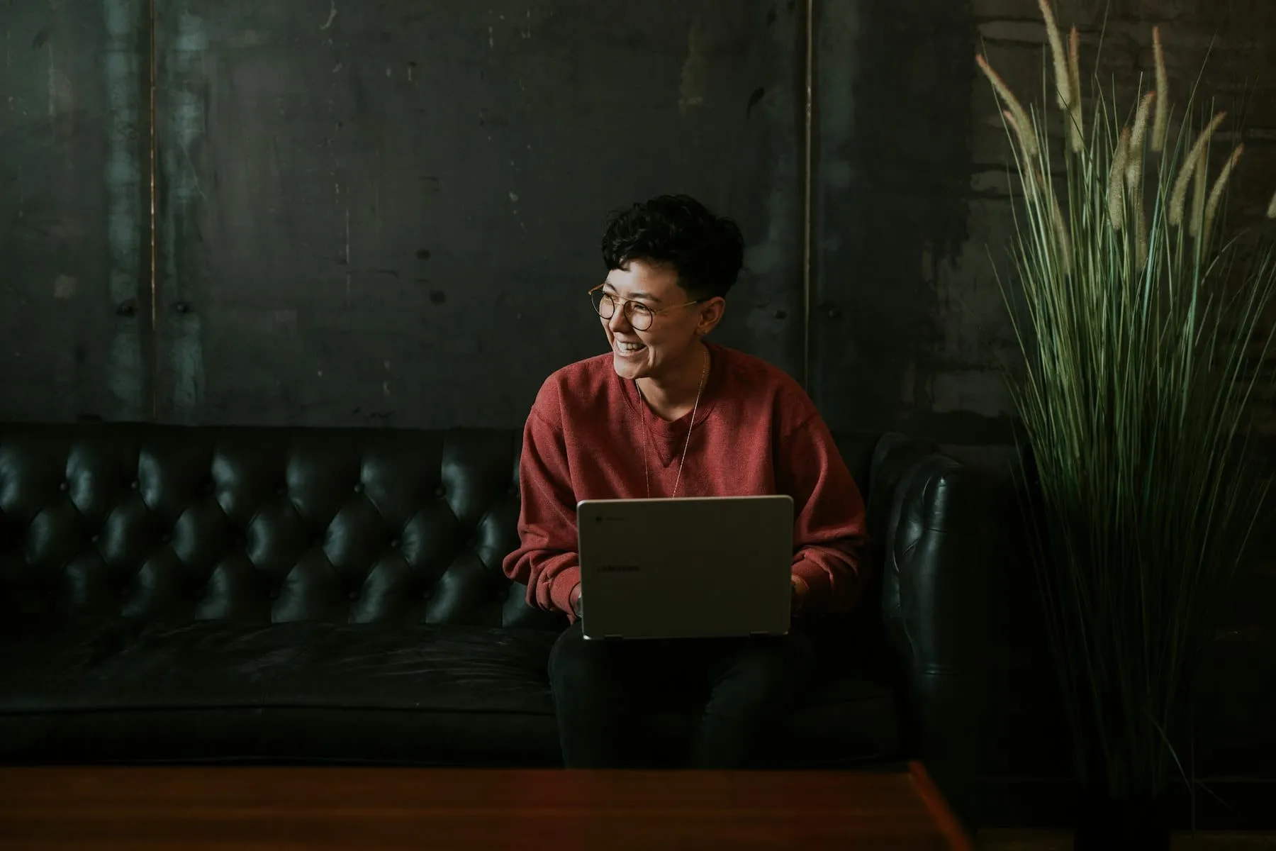 A person searching on a laptop with a coffee beside them