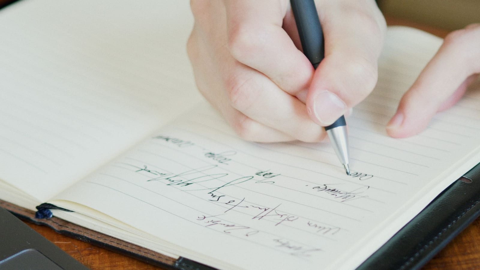 Hand writing a line in a notebook