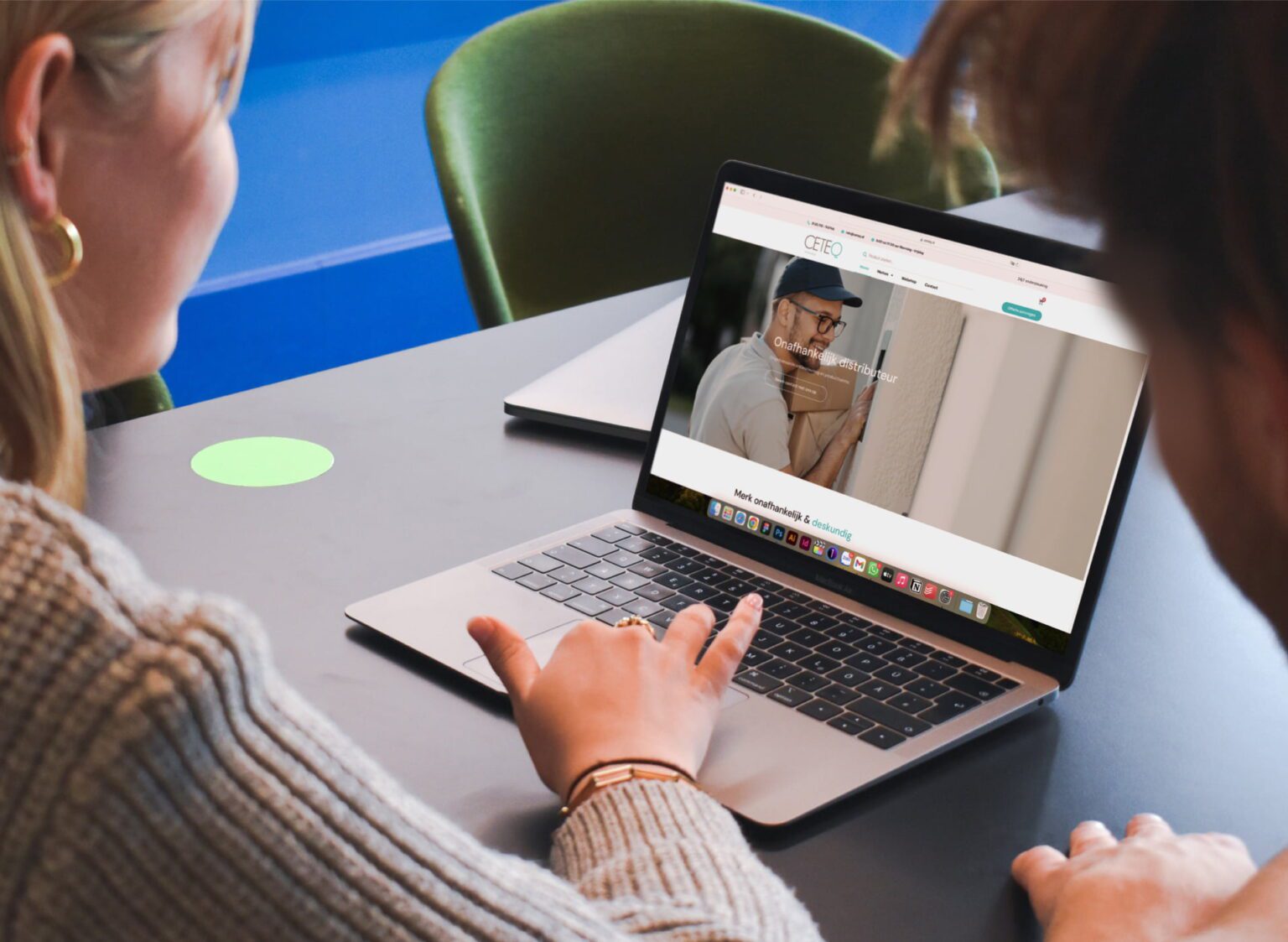Hai người cùng xem website của một doanh nghiệp trên laptop