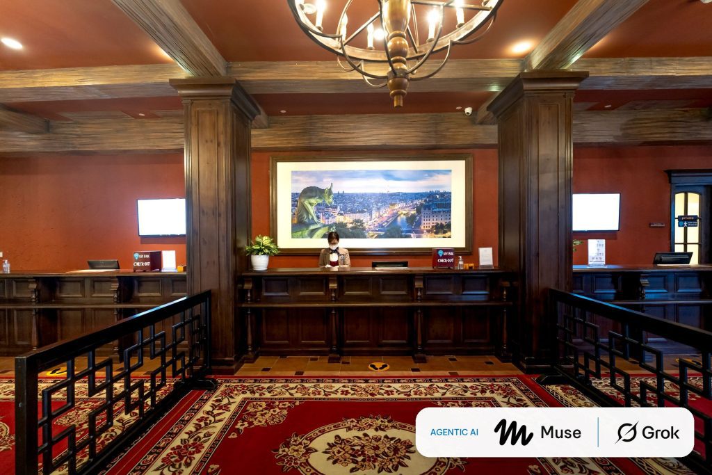 Receptionist at the front desk of a warmly lit hotel lobby, with a badge showing the Meta Muse and Grok logos for agentic AI