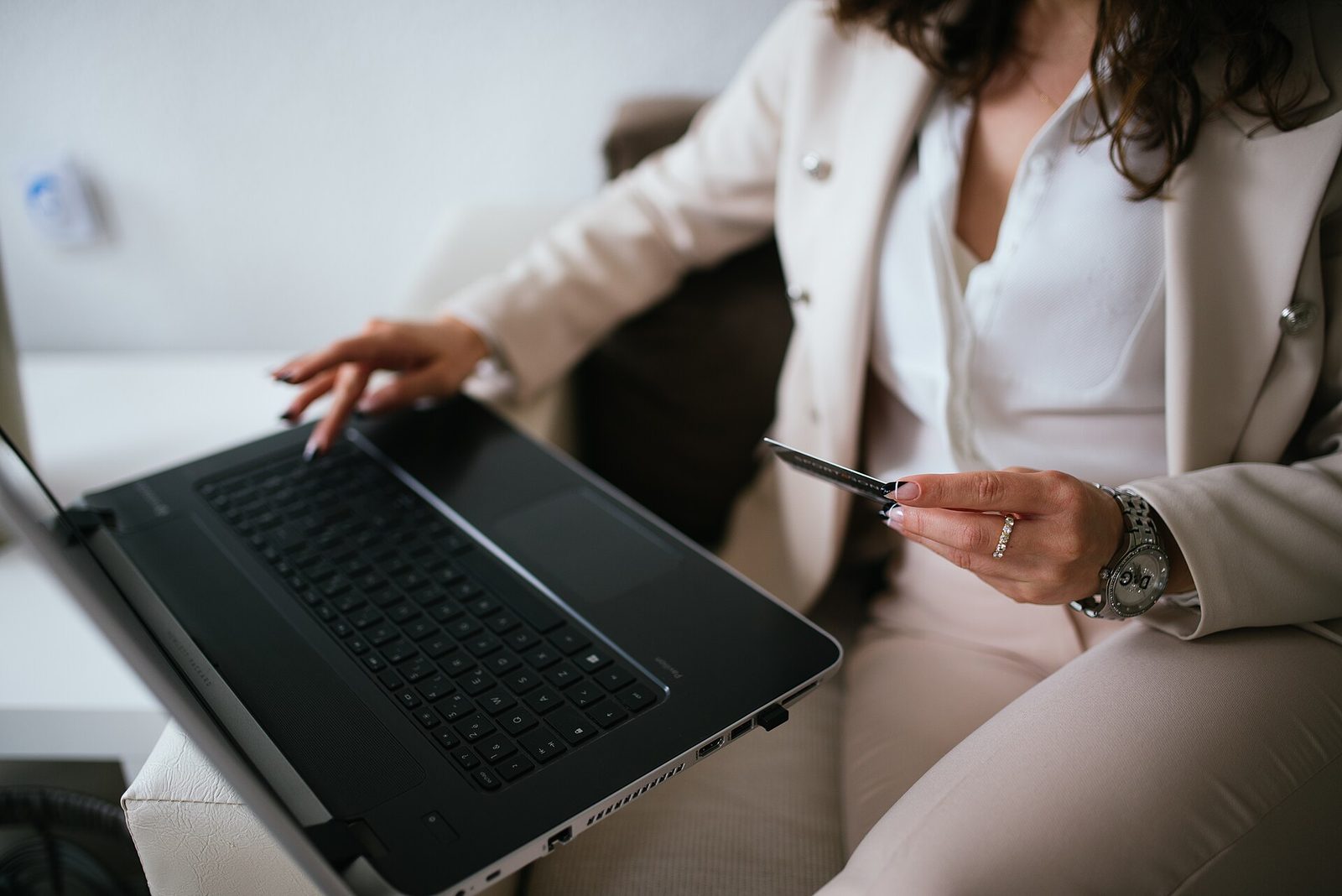 Person holding a credit card while completing an online booking on a laptop