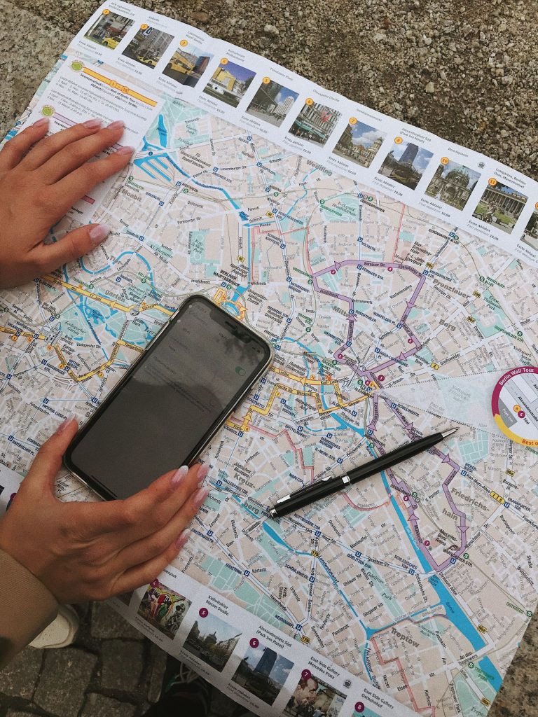 Traveller planning a trip with a smartphone on a city map, the way guests now research and book hotels